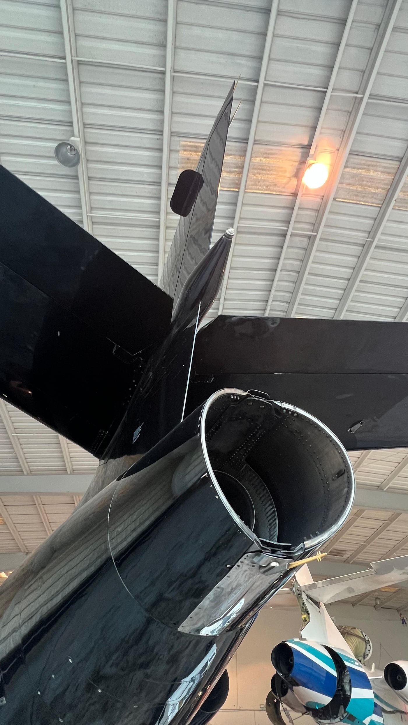 A close view of a jet engine and tail inside the hangar